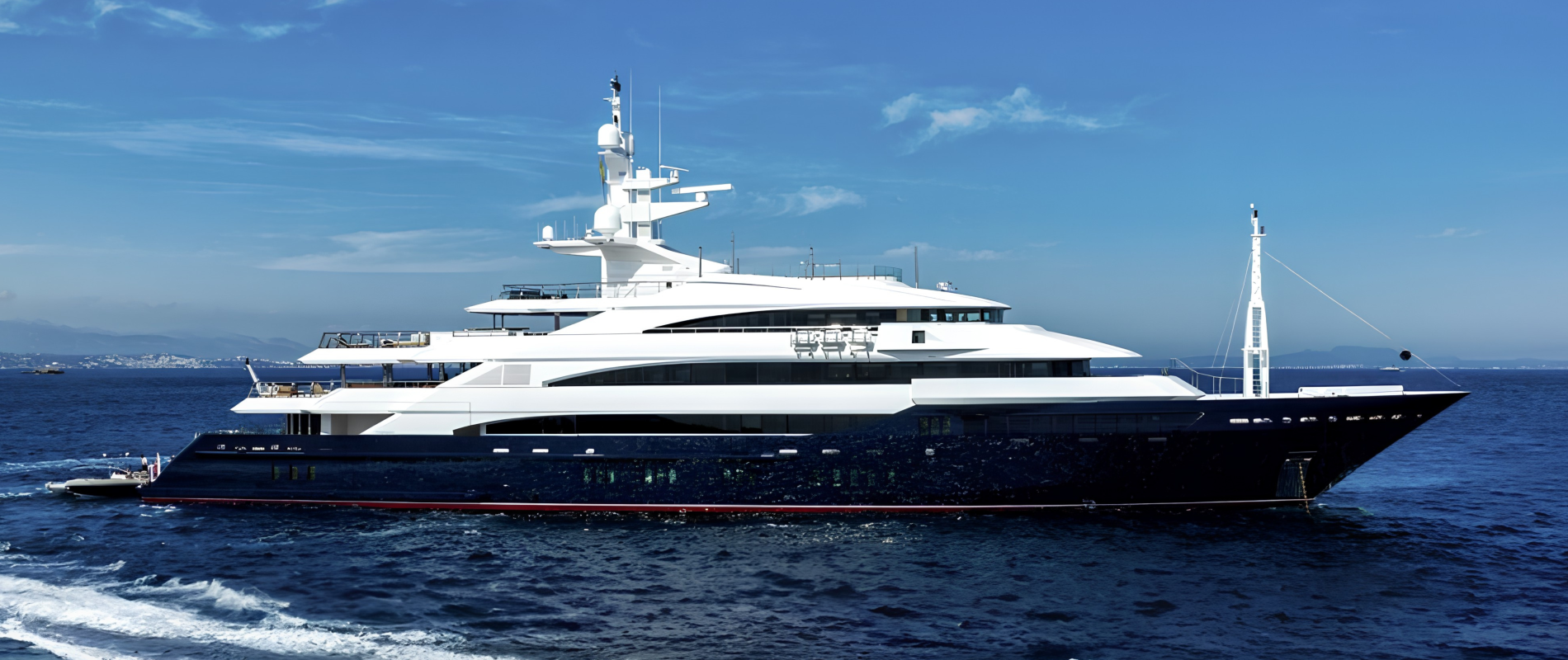 Side profile of a luxury superyacht with a dark navy hull